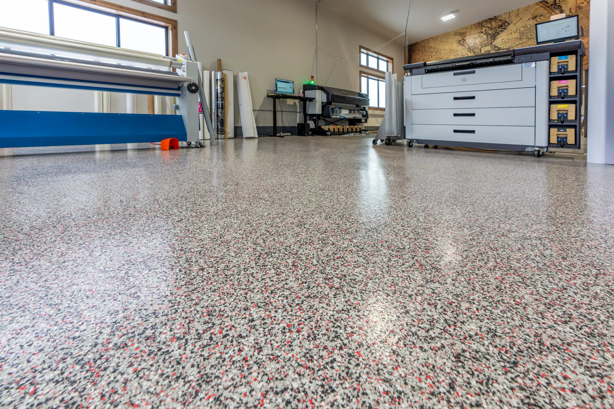 Epoxy and polyurea floor coatings applied in a commercial print shop for enhanced durability and a clean, professional look.
